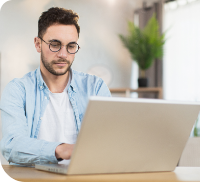 A man using a laptop in an office environment.