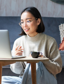 Smiling woman with glasses exploring Sulvo’s careers page on a laptop at a desk.