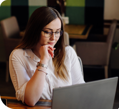 A woman using a laptop in an office environment.